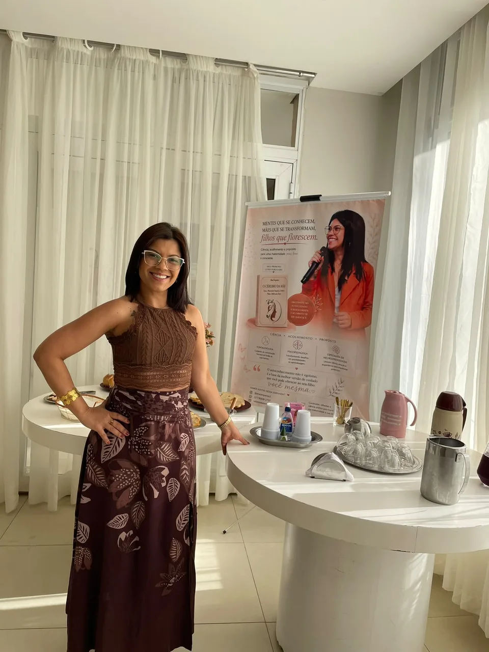 Ana Cerqueira ao lado de um painel de apresentação sobre seu trabalho